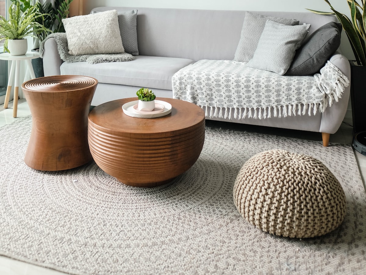 A tidy, naturally lit living room with a sofa and large window